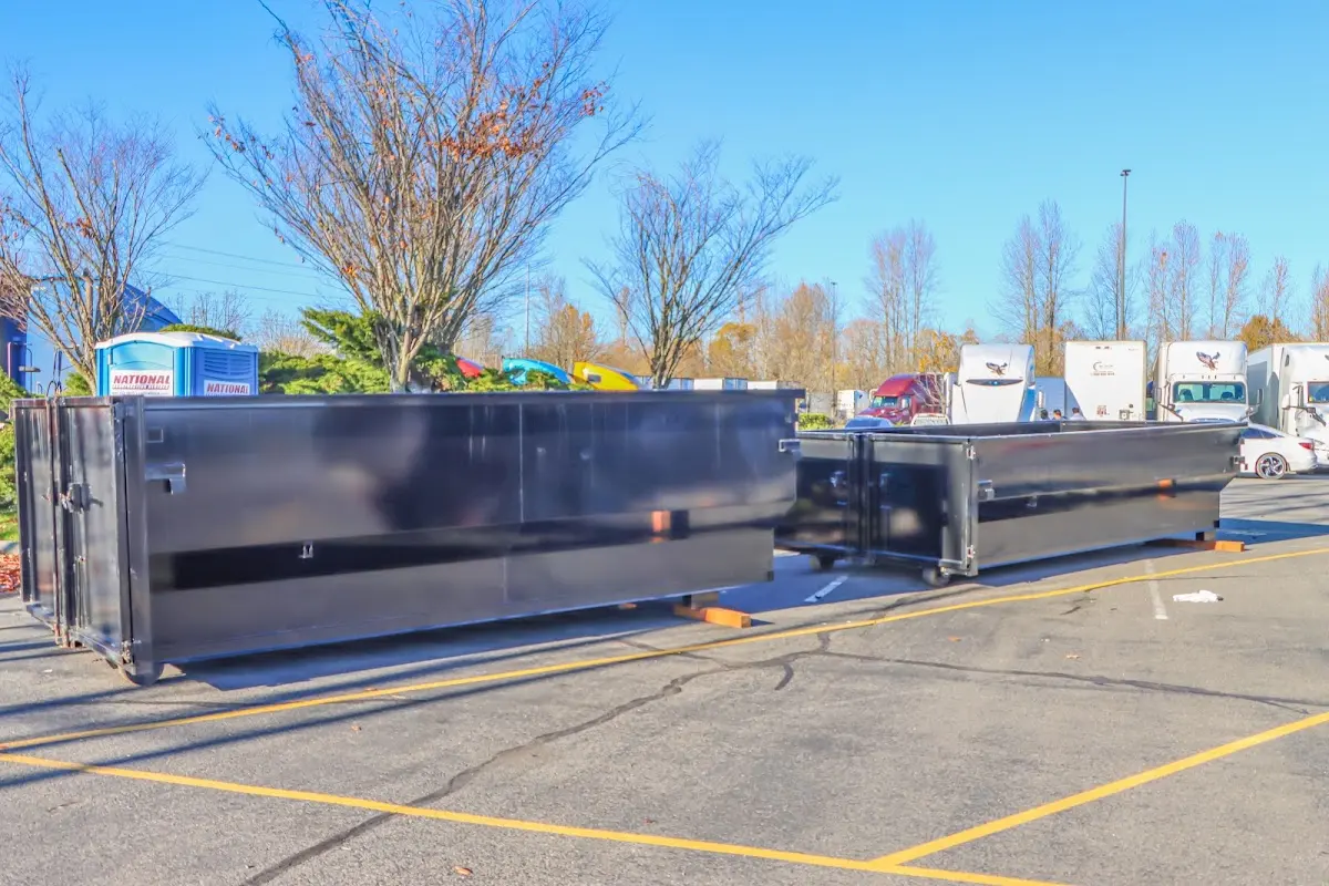 Professional dumpster rental service with roll-off container on residential driveway in Valley Falls